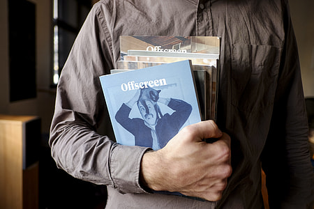 person holding several books thumbnail