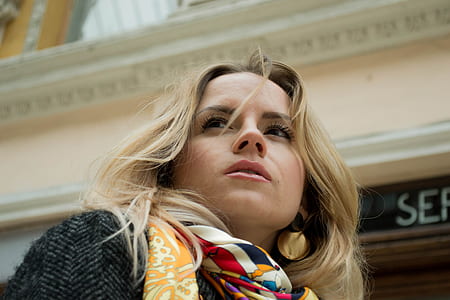 woman wearing scarf facing right near beige building thumbnail