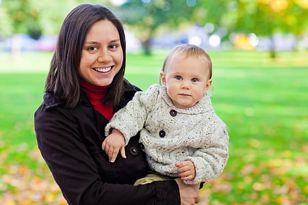 woman carrying baby during daytime thumbnail