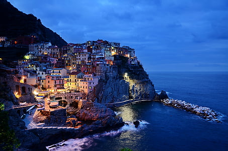 lighted houses near body of water during nighttime thumbnail