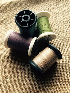 four assorted-color thread rolls thumbnail
