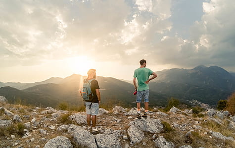 two men standing on rocks during daytime thumbnail