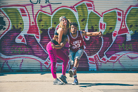 man and woman standing near graffiti wall art thumbnail