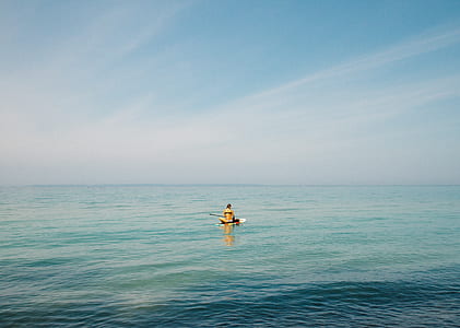 person riding on boat surrounded by body of calm water during daytime thumbnail