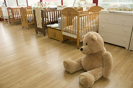 brown bear plush toy besides brown wooden cribs and dresser thumbnail