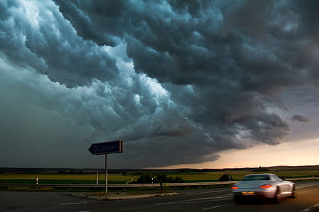 silver coupe on road under gray sky thumbnail