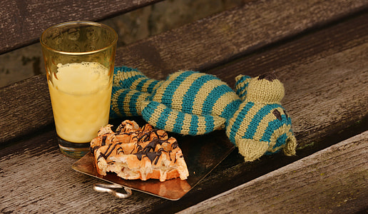 glass filled with yellow juice and Belgian waffle served on tray thumbnail