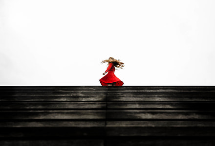 standing woman in red long-sleeve dress during daytime thumbnail