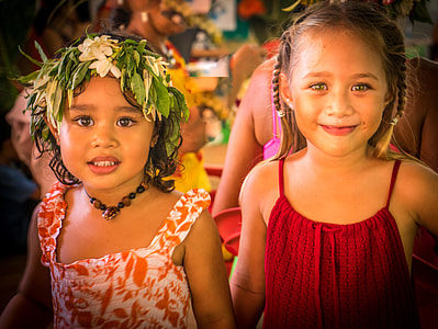 girl wearing white floral headpiece standing beside another girl wearing red spaghetti strap dress thumbnail