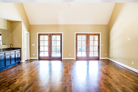 beige painted wall with two brown wooden-framed 8-lite doors on brown wooden parquet thumbnail