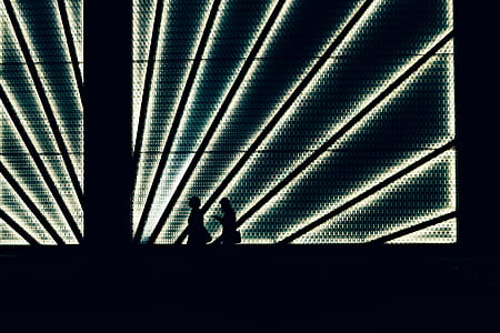 two women's silhouettes in front of LED light thumbnail