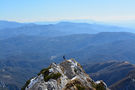 man on top of rock mountain during daytime thumbnail
