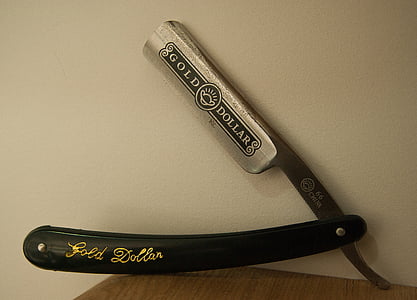 silver straight razor on wooden board thumbnail