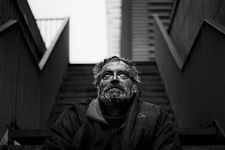 grayscale photo of man sitting on staircase thumbnail