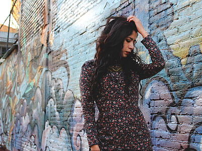 woman holding her head near graffiti wall thumbnail