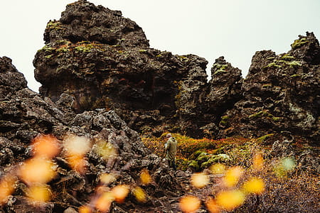 A photographer at volcanic rocky hills covered with grass thumbnail