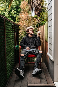 man sitting on red armchair thumbnail