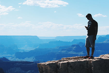 silhouette photo of man standing on mountain cliff thumbnail