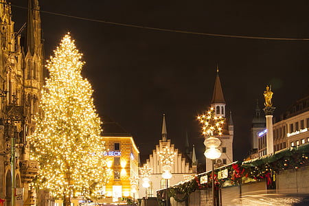 tree and building with yellow string lights during night time thumbnail