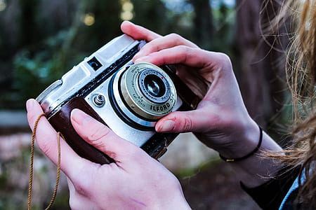 woman holding gray and black SLR camera thumbnail