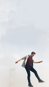 man standing on mountain peak balancing thumbnail