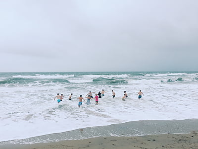 people swimming on sea during daytime thumbnail