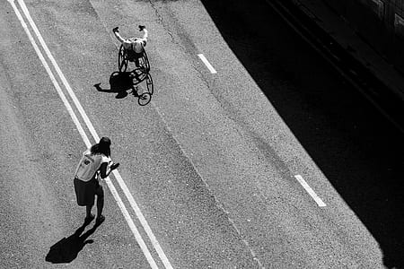 person riding wheelchair on road thumbnail