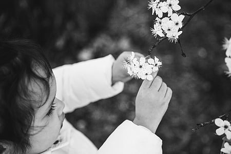 grayscale photography of toddler holding flower thumbnail