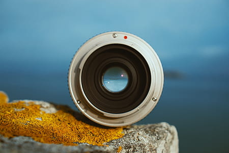 white and black camera lens on gray concrete surface thumbnail