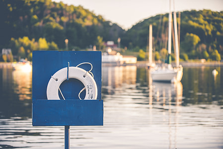 selective focus photography of white floater far away from boat thumbnail