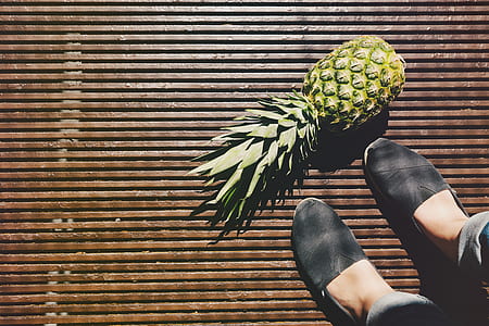 person standing beside pineapple thumbnail