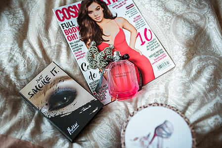 Cosmopolitan magazine with fragrance bottle on gray cloth thumbnail