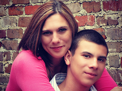 woman in pink long-sleeved top hugging a man in white collared top thumbnail