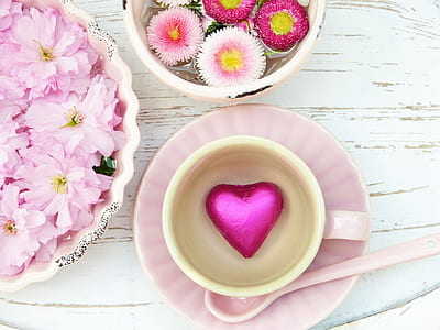 flowers in bowl beside cup on saucer thumbnail