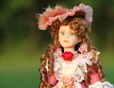 selective focus photography of porcelain girl doll wearing white and pink dress thumbnail