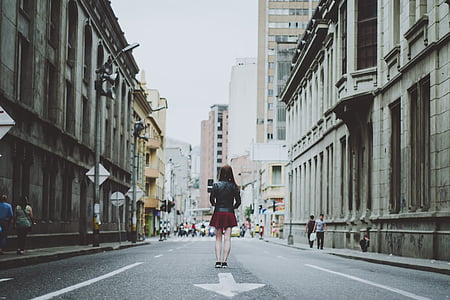 woman wearing red skirt standing in the middle of the city road thumbnail
