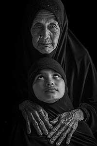 grayscale photo of woman and girl wearing black headscarves thumbnail