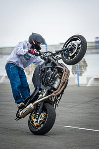 man doing motorcycle stand during daytime thumbnail