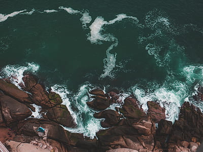 aerial view from top of mountain cliff with teal ocean water during daytime thumbnail