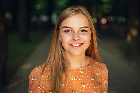 woman with orange crew-neck shirt selective focus photography thumbnail
