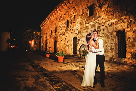 woman kiss the cheek of man beside concrete building thumbnail