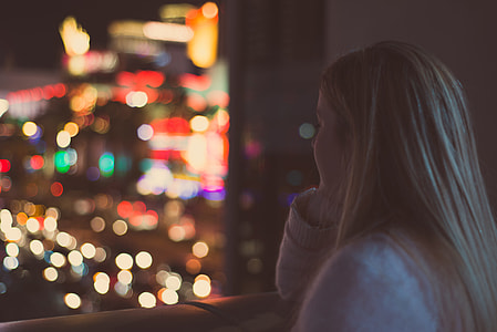 woman resting her hand and facing the high rise buildings thumbnail