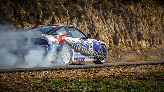 white and blue racing car on black concrete road thumbnail