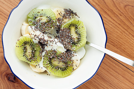 sliced kiwi with toppings on white bowl thumbnail