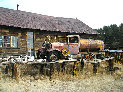 brown and yellow truck near brown wooden house thumbnail