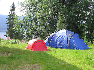 two blue and red tents near body of water thumbnail
