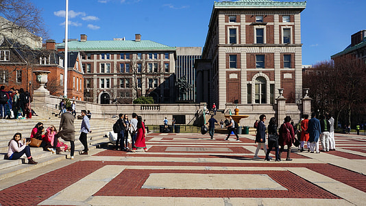 people walking beside building under white clouds and blue sky thumbnail