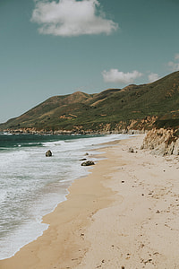 body of water beside mountain under white cloudy sky at daytime thumbnail