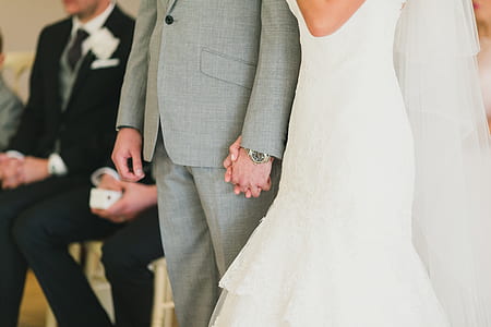 bridge and groom holding each others hand in selective focus photography thumbnail