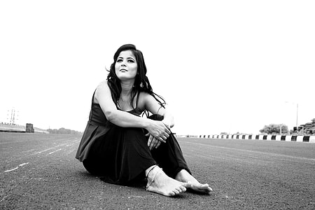 gray scale photography of woman sitting on pavement thumbnail
